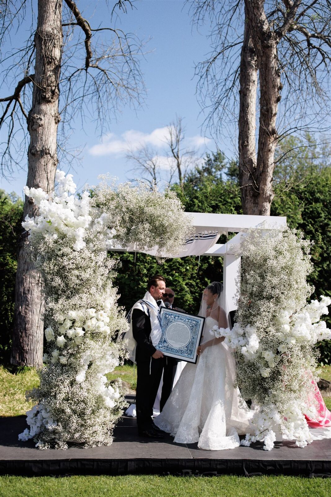 Baby's Breath Chuppah - Cloud-like baby's breath and white rose chuppah under open sky by Aura Floral Design Miami