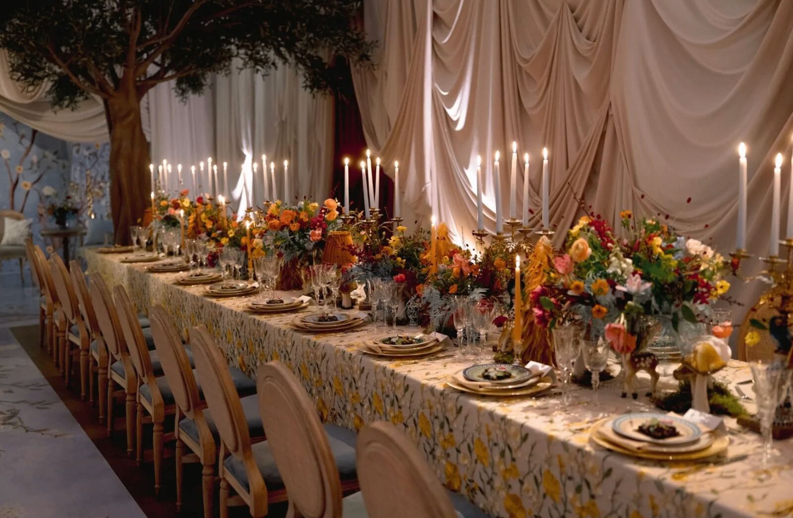 Enchanted Garden Dinner - Olive trees, draped fabric, and wildflower runner with glowing taper candles by Aura Floral Design Miami
