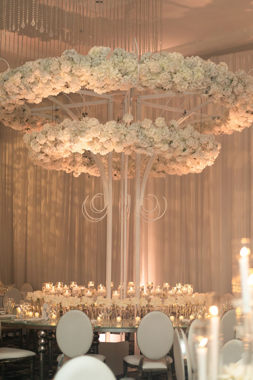 Grand Table Arrangement - Towering white rose and hydrangea centerpiece with cascading crystal accents by Aura Floral Design Miami