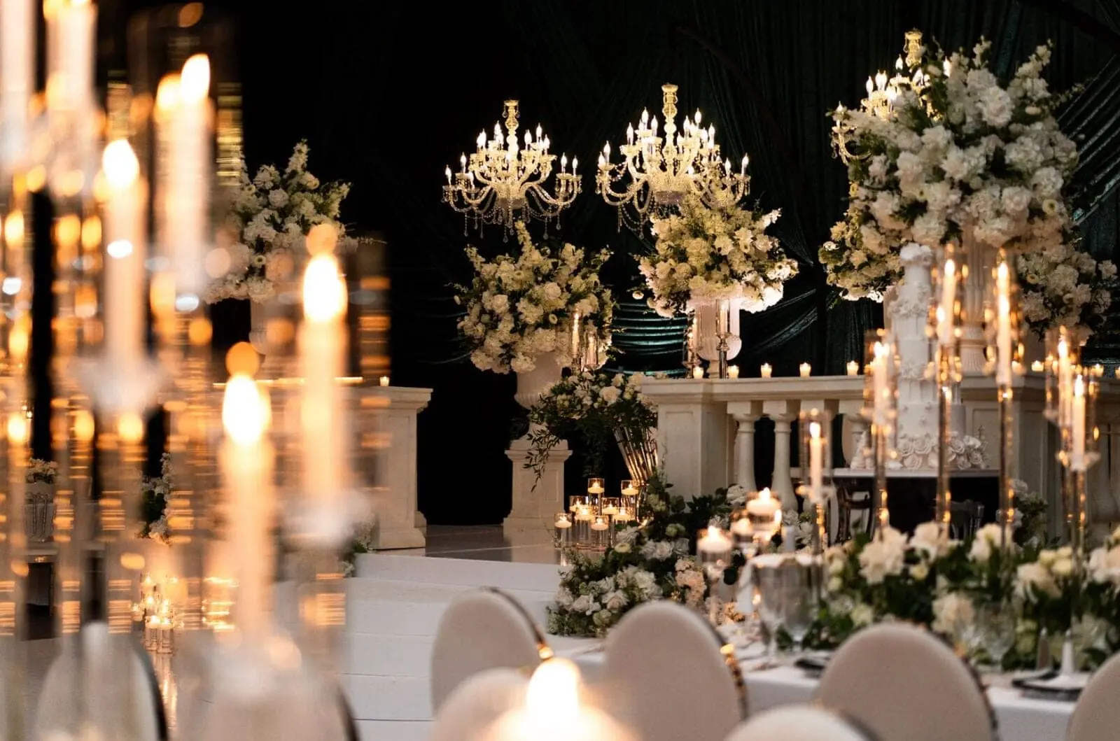 Chandelier Ceremony - Towering white floral pedestals and crystal chandeliers against an emerald draped backdrop by Aura Design Flowers Miami