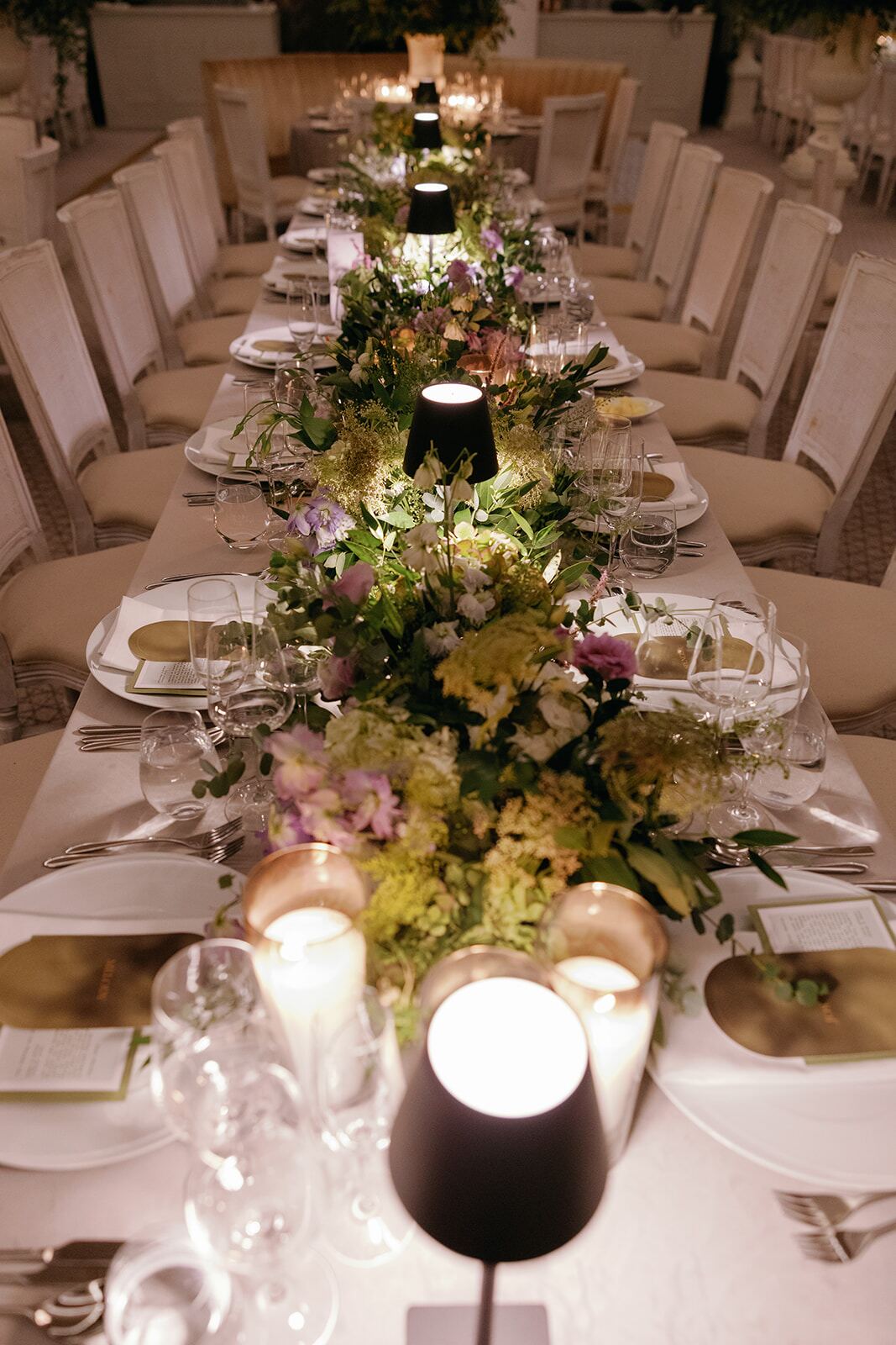 Garden Table Runner - Lush pastel floral runner glowing with candlelight along a long banquet table by Aura Floral Design Miami
