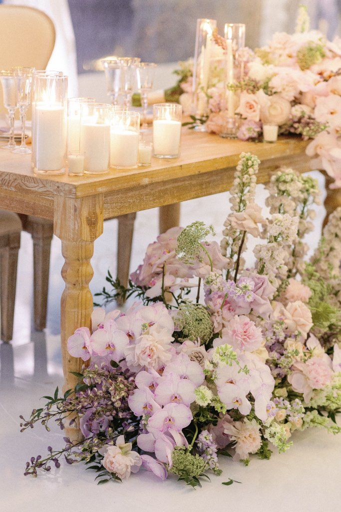 Floral Cascade - Lavish orchid arrangements spilling from the table by Aura Floral Design Miami