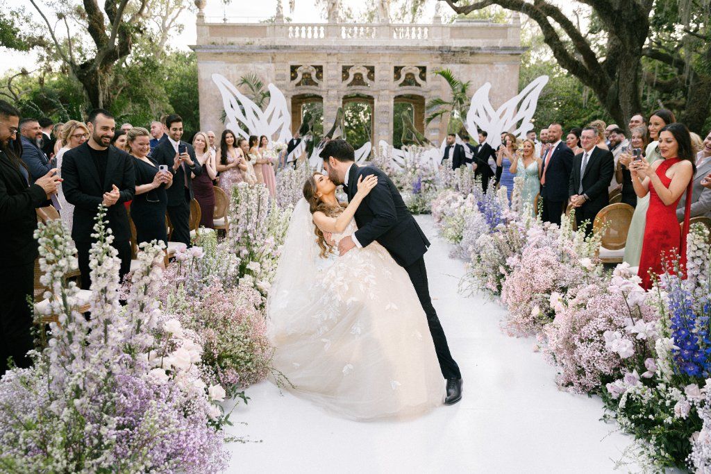 The First Kiss - Ceremony surrounded by a lush floral aisle by Aura Floral Design Miami